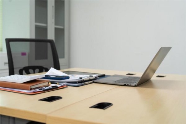 a desk and chair with a laptop and papers.